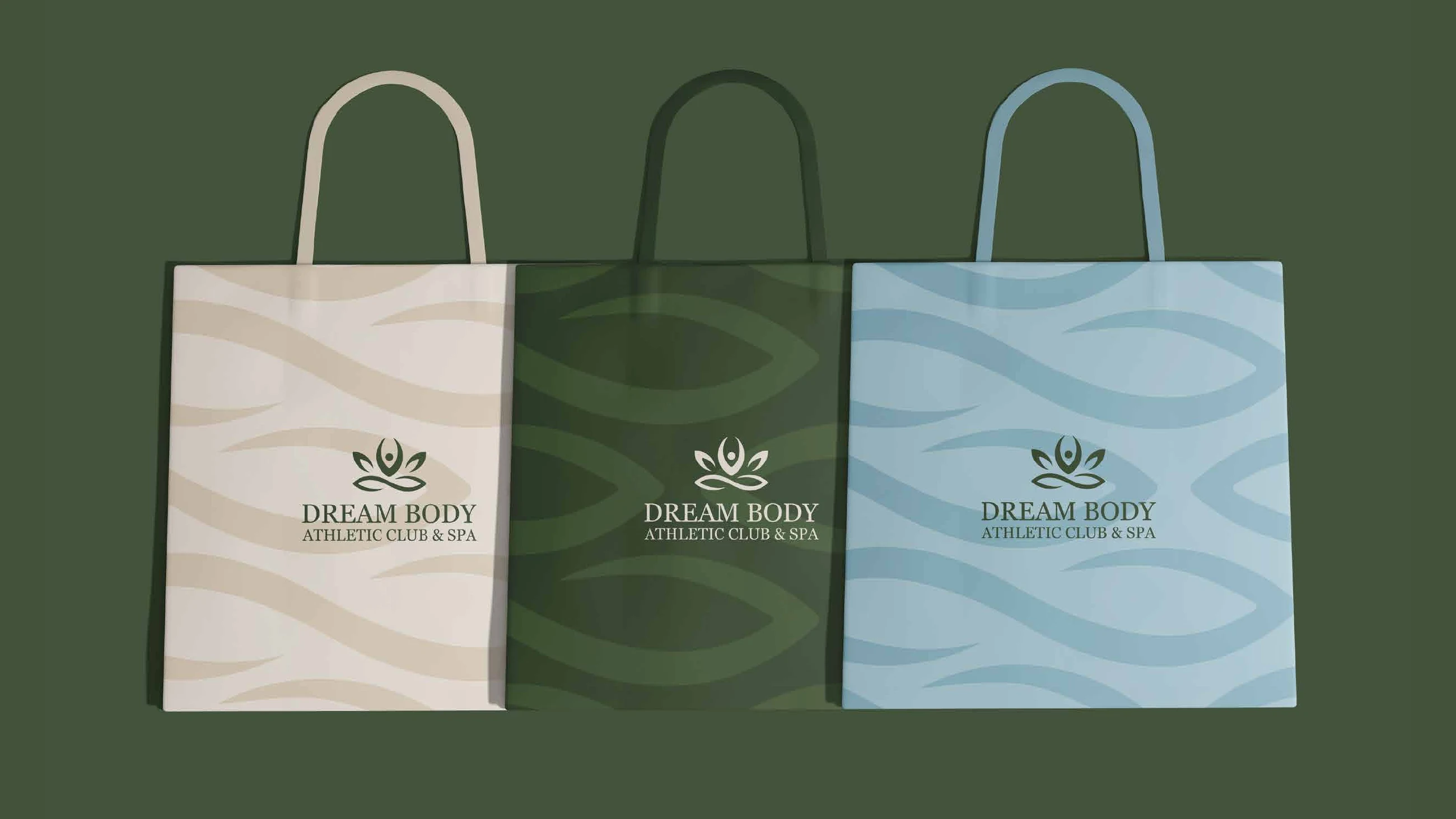 Three Dream Body shopping bags in cream, dark green and pale blue with the wave pattern