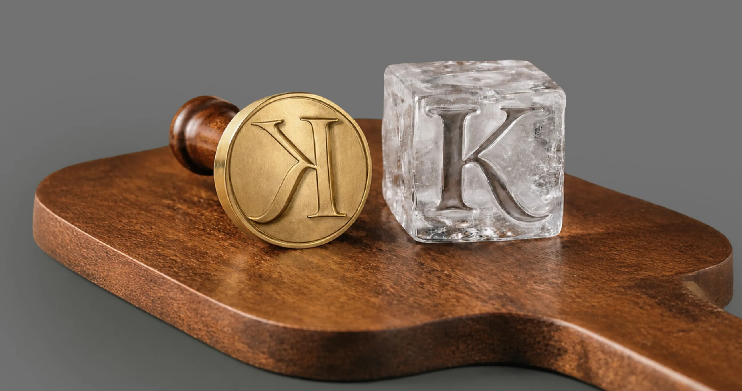 A brass ice stamp and an ice cube pressed with the K